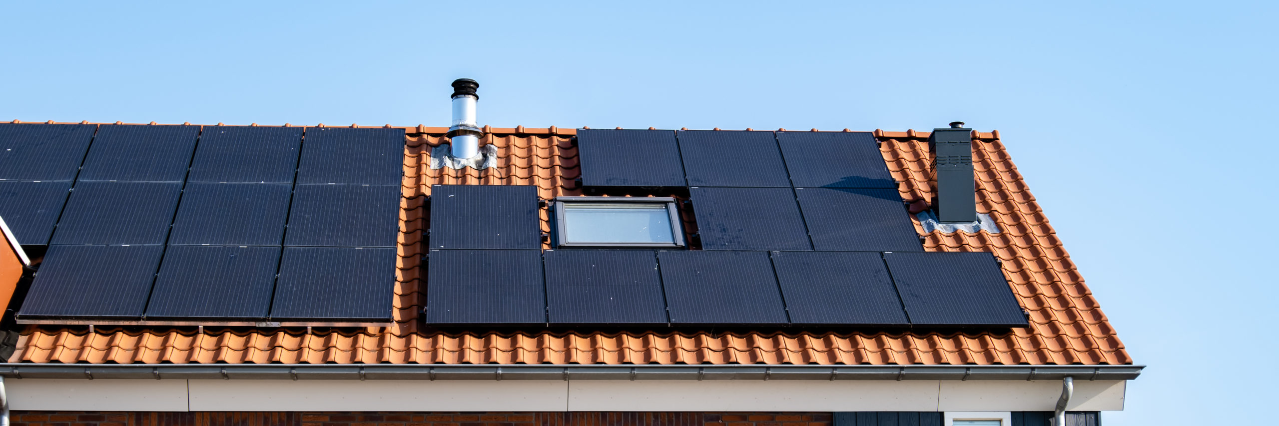 Newly build houses with solar panels attached on the roof against a sunny sky