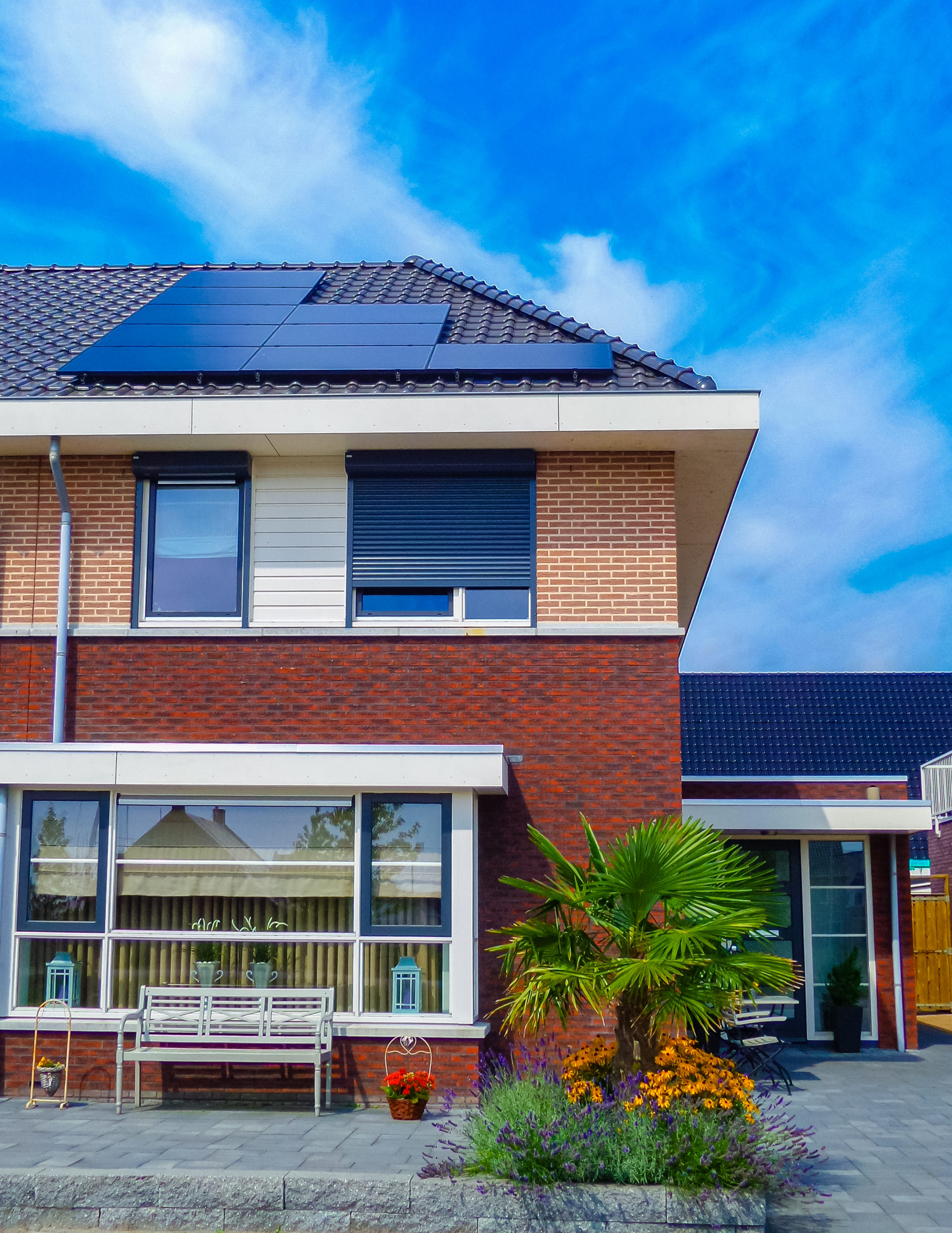 Newly build houses with solar panels attached on the roof against a sunny sky